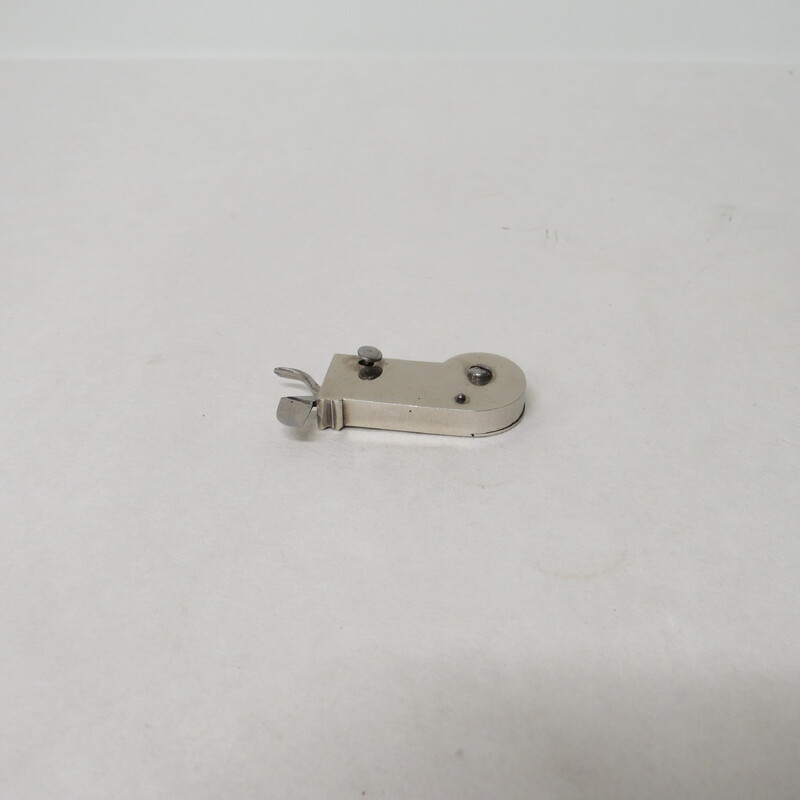 A white metal spring lancet with a button trigger