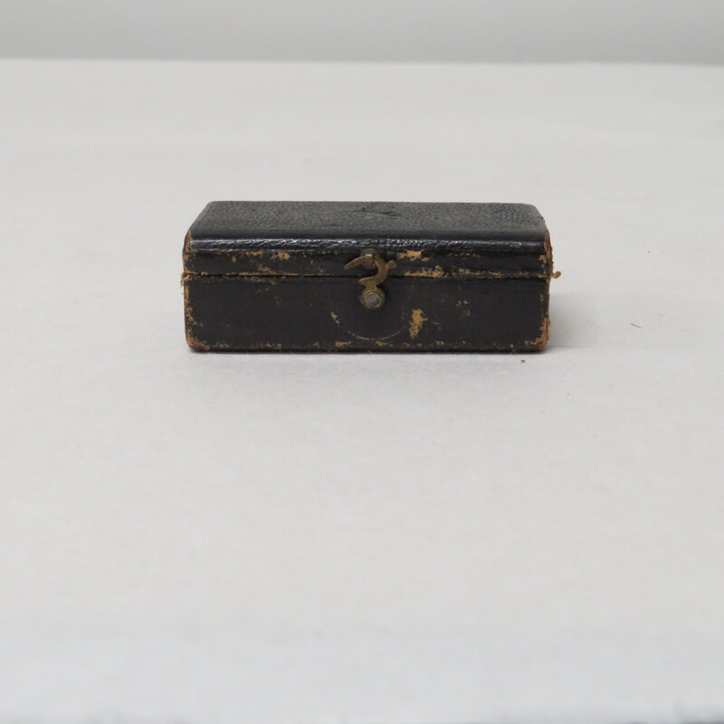 a paper box lined with velvet, closed by latch.