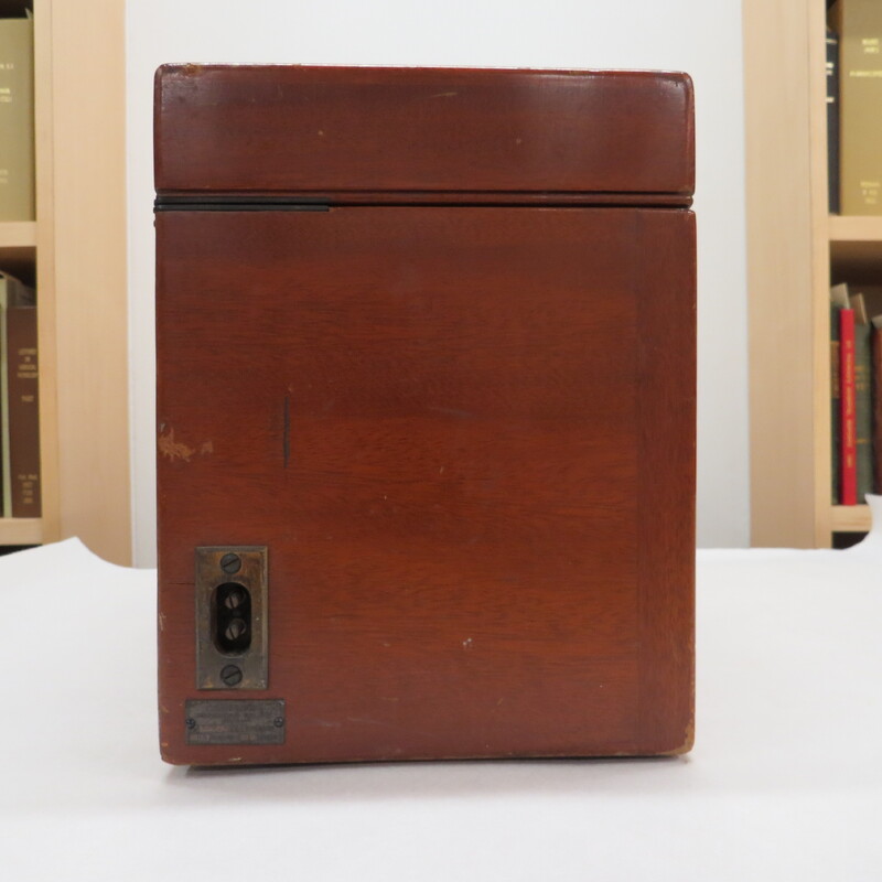 A wooden case with a handle and a brass plaque inscribed: "Made for Bernard Fuchs MD." Case contains portable electrocardiograph. Unlike earlier battery powered photographic models, this is an AC powered instrument.