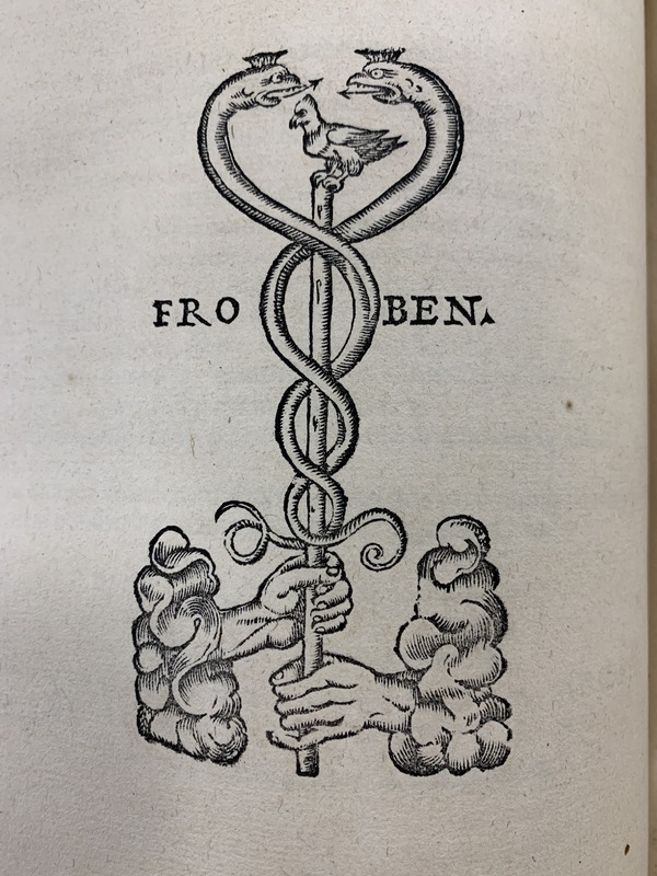 Hieronymus Froben's printer mark, showing two hands holding a staff with two snakes wrapped around it and a bird on top. The word "Froben" surrounds the staff.