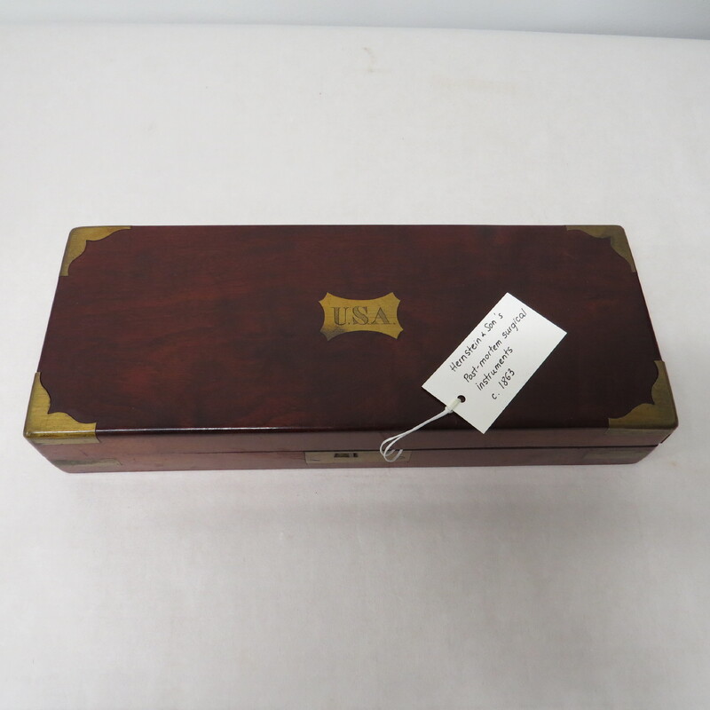 A post mortem surgical wooden tool box with USA labeled on it.