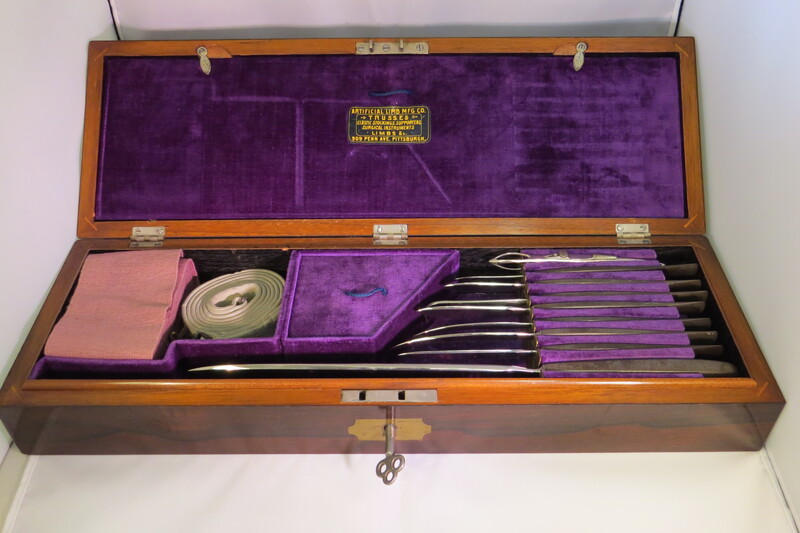 Surgical set. Set includes: 8 surgical knives, 1 artery forceps, 5 surgical needles, 1 elastic bandage, 1 tourniquet with an iron chain, 1 Galt's trephine,  1 trephine handle, 1 trepanning elevator and rasps, 1 lithotomy forceps