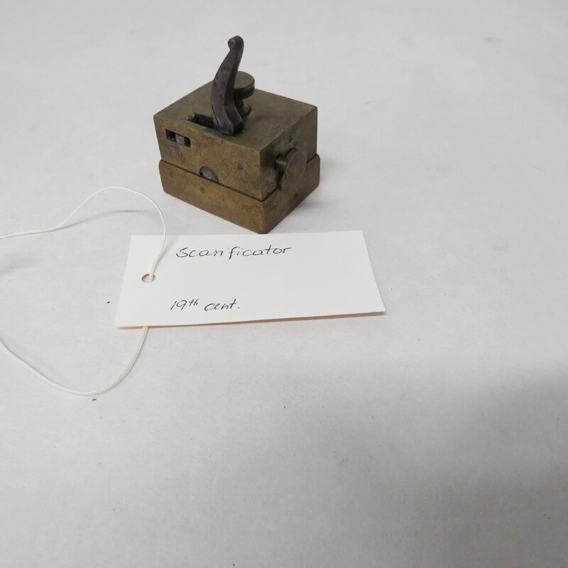 Sixteen-bladed square brass scarificator, blades arranged on three rods, cutting in the same direction. 