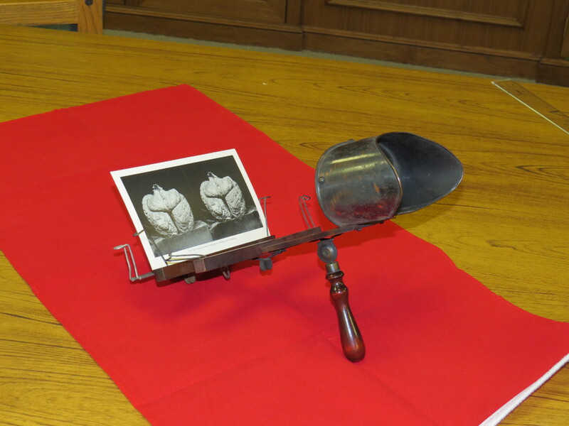 An antique viewer for stereoscopic images with 3 card holders.