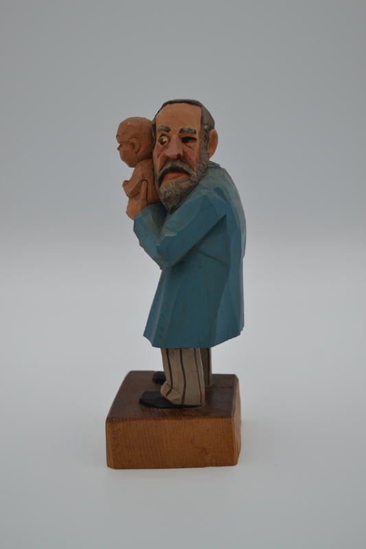 A wood figurine of pediatrician with inscription: "Constipation? - Rhubarb!" in German