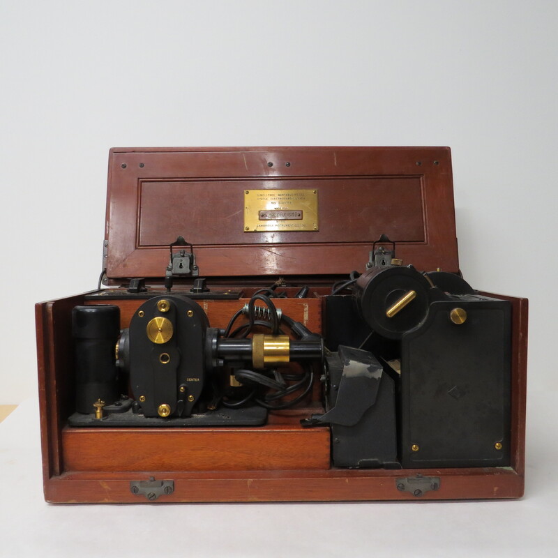 A wooden case with a handle and a brass plaque inscribed: "Made for Bernard Fuchs MD." Case contains portable electrocardiograph. Unlike earlier battery powered photographic models, this is an AC powered instrument.