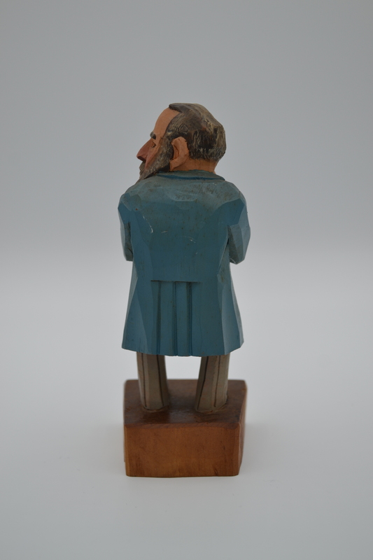 A wood figurine of pediatrician with inscription: "Constipation? - Rhubarb!" in German