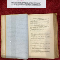 Open book. Handwritten sheet of notes is shown on the left page. The right page shows text from a textbook, with handwritten annotations on the page.